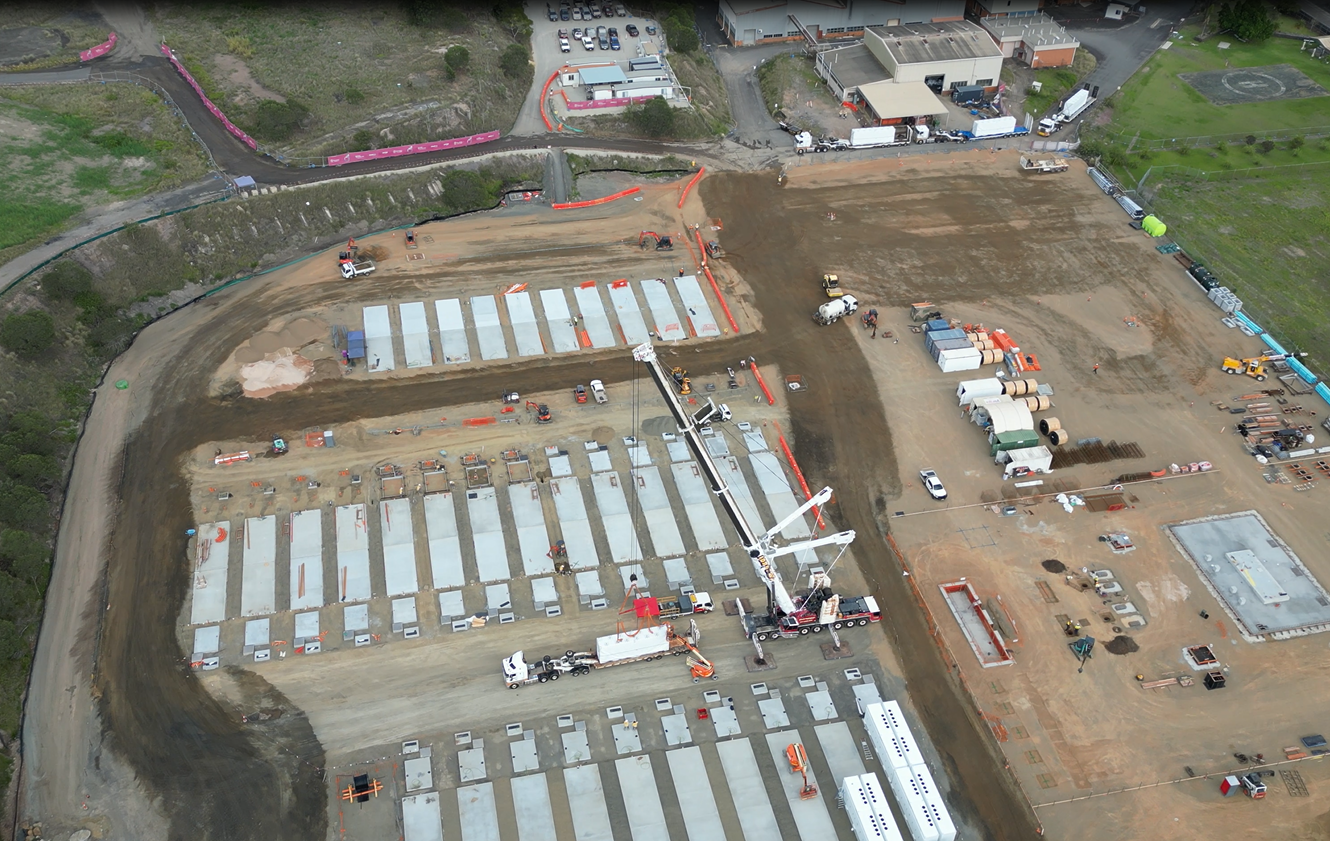 Aerial view of the Swanbank Battery site — Tesla Megapack foundations laid out across the former coal station site, crane lifting units into place (photo courtesy of Yurika)